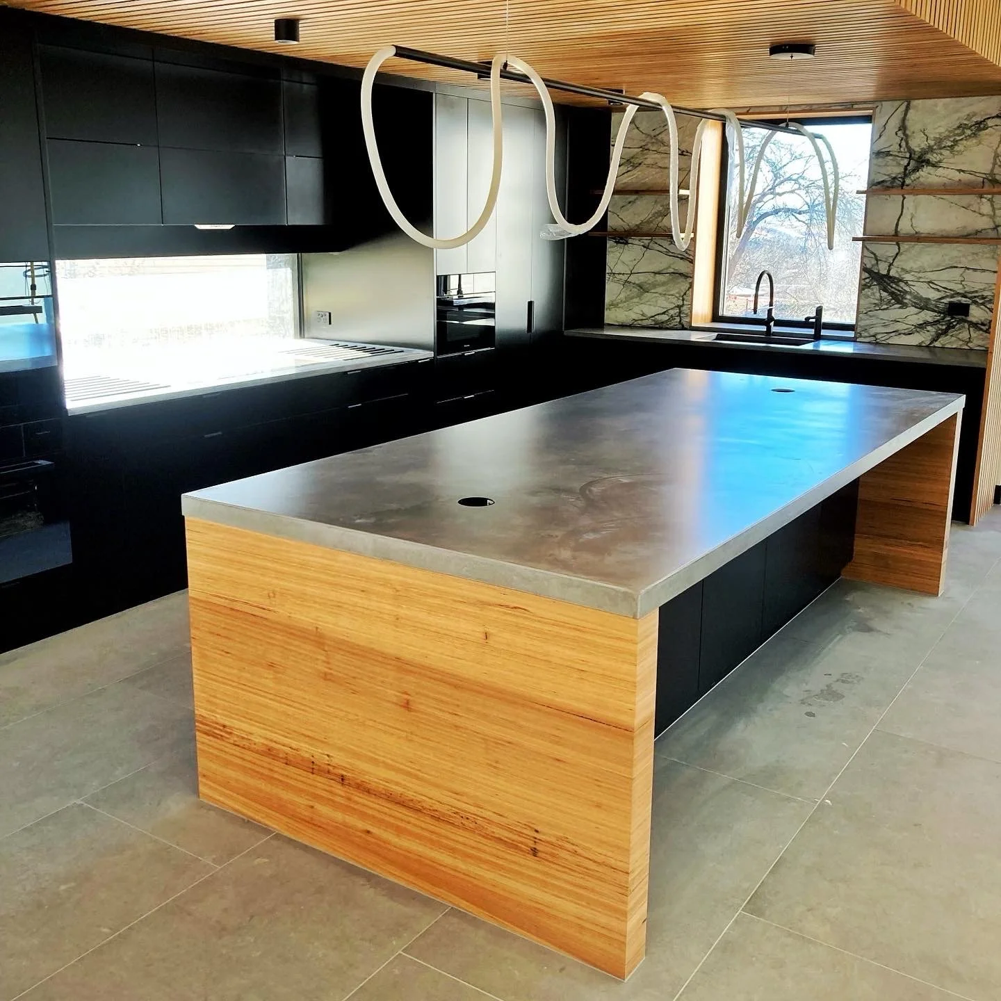 Custom concrete benchtop with integrated timber base in a contemporary kitchen design Melbourne