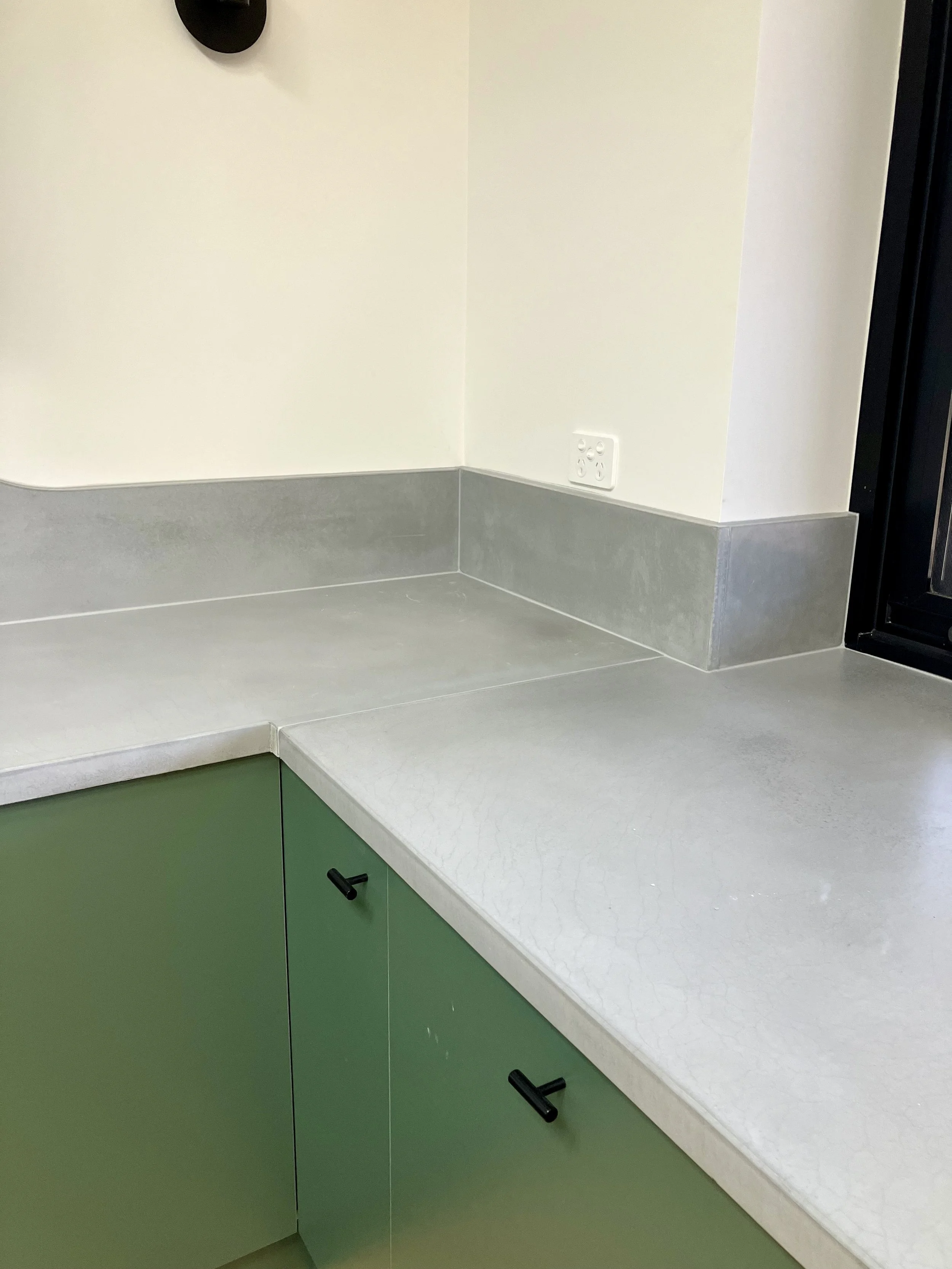 Custom concrete benchtop with integrated splashback and clean edge detail in a Melbourne kitchen