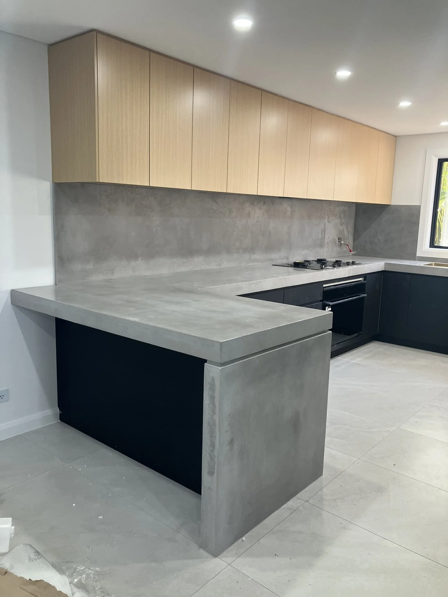 Wall-mounted concrete benchtop with seamless finish and window splashback Melbourne