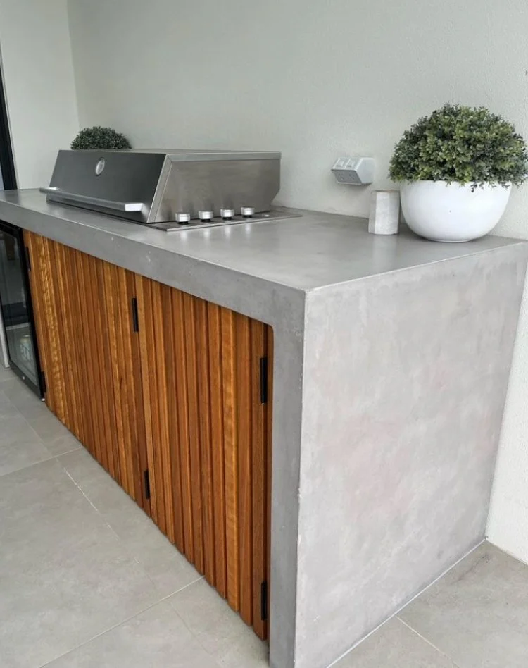 Concrete outdoor kitchen with wood panel doors