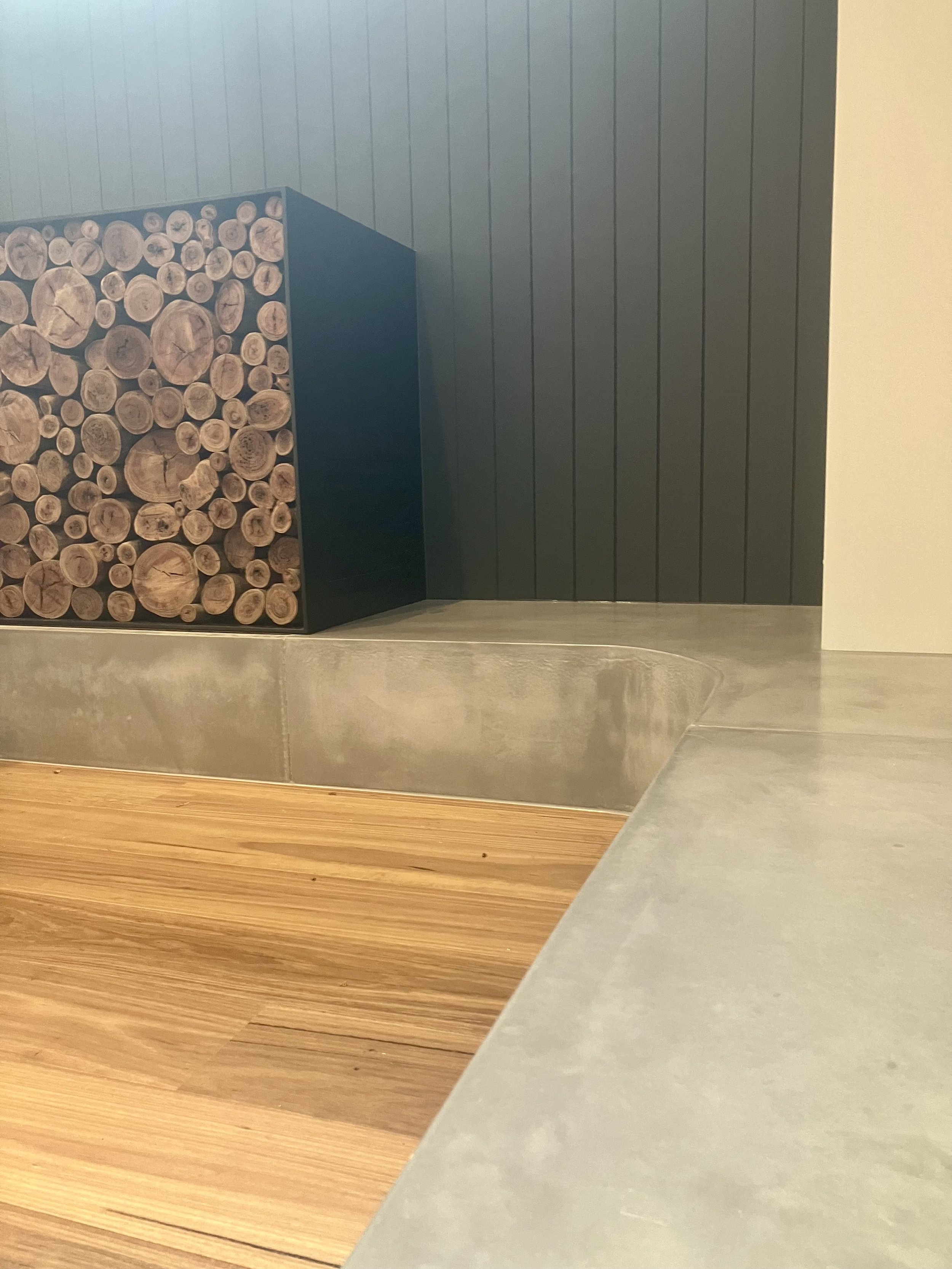 Solid plinth concrete fireplace hearth in Melbourne with integrated firebox and geometric form.