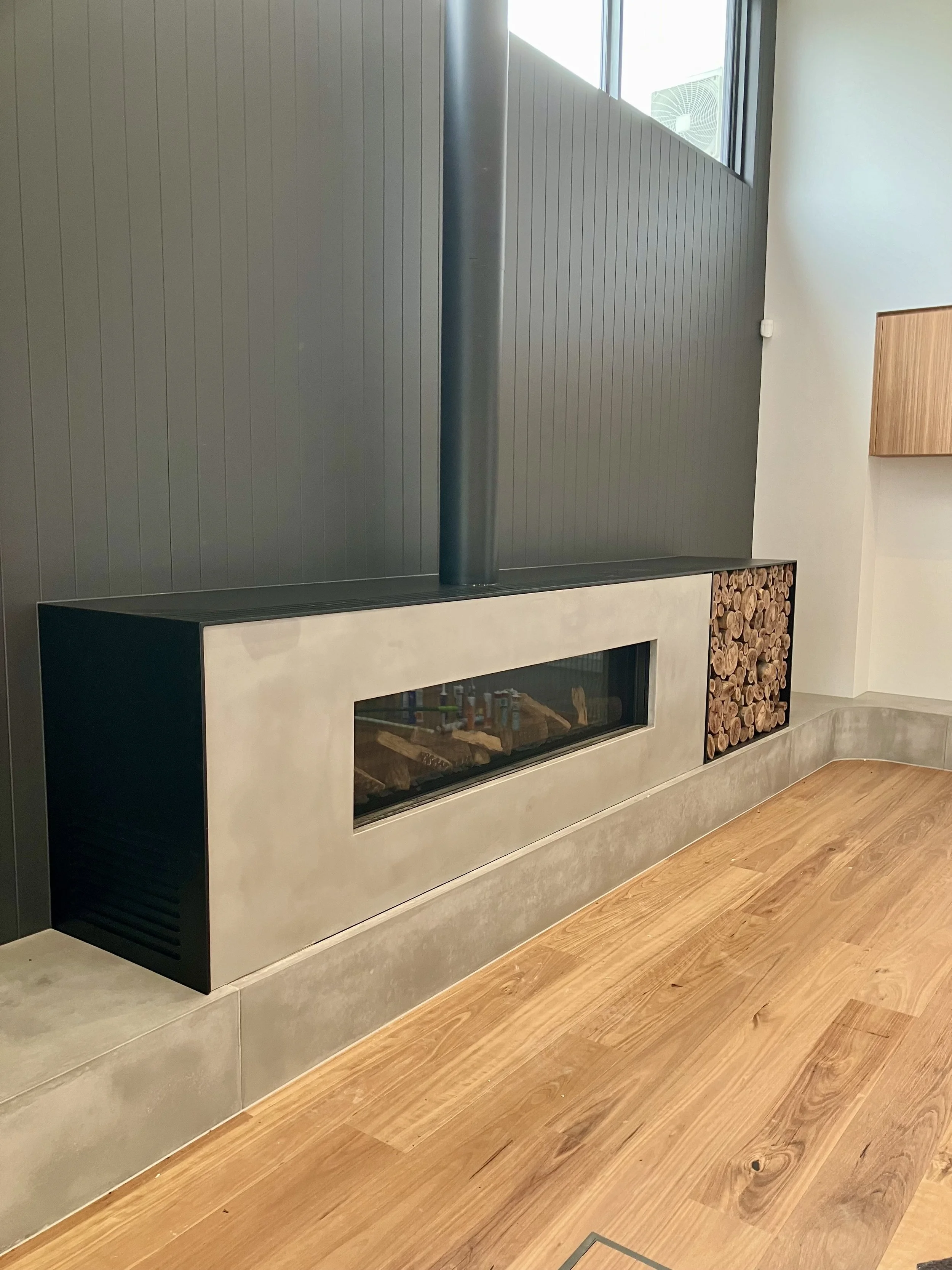 Custom concrete hearth installed in a modern Melbourne home, creating a seamless wall-mounted look. 