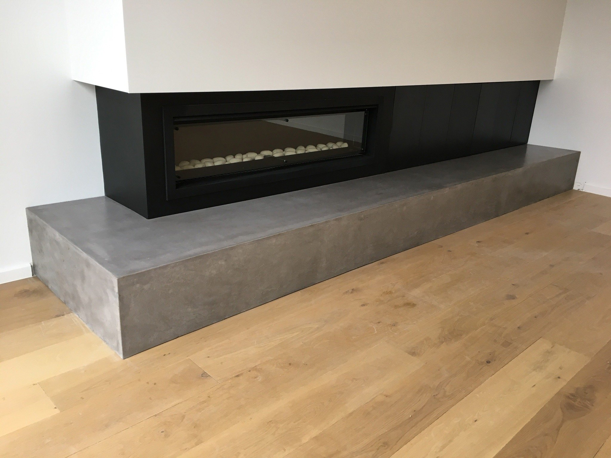 Concrete fireplace hearth in Melbourne with concealed steel supports and clean minimalist finish.