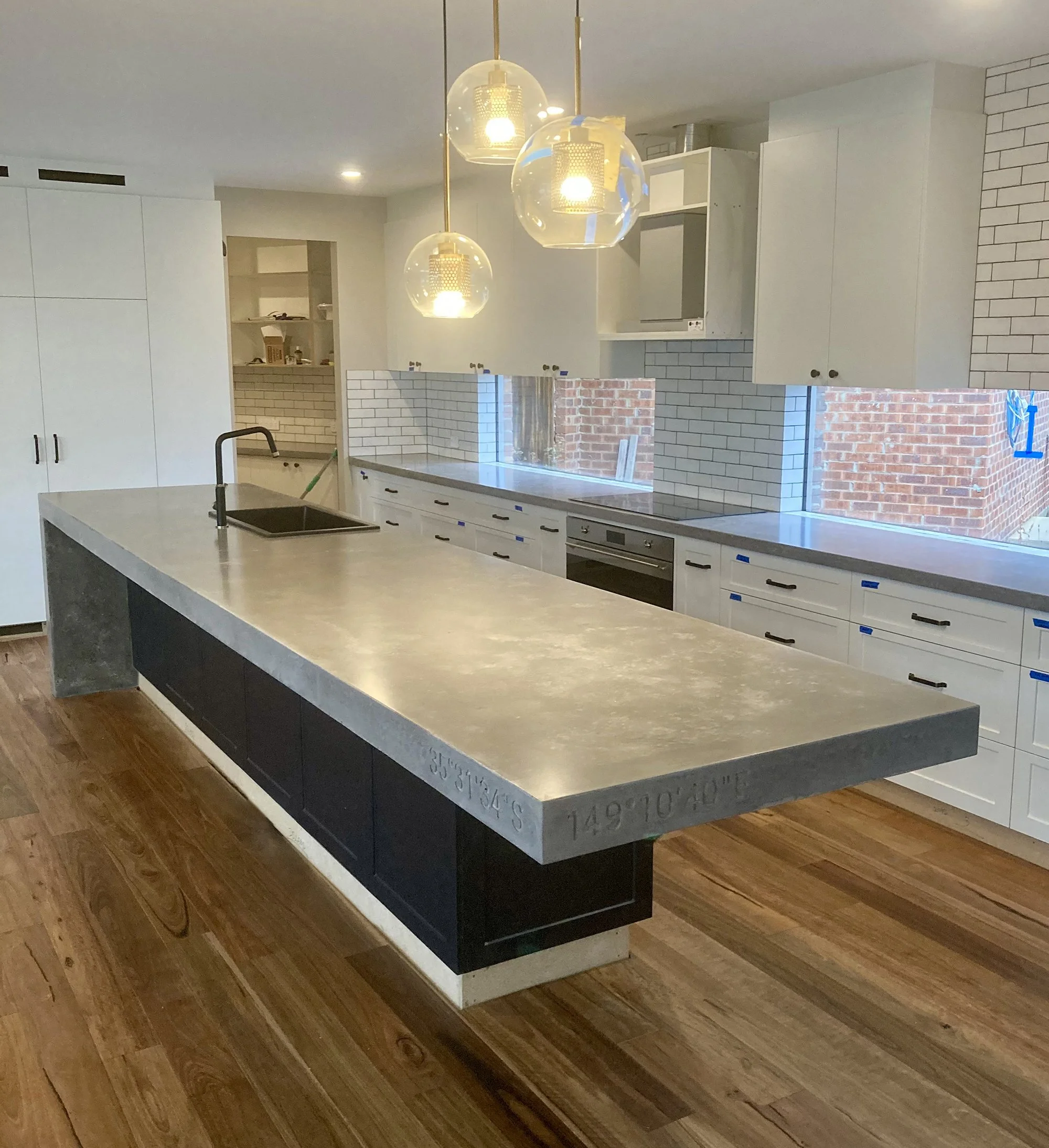 Large custom concrete kitchen island with waterfall edges in a modern Melbourne home