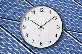 Clock showing 9:11 against a background of a building with solar panels.