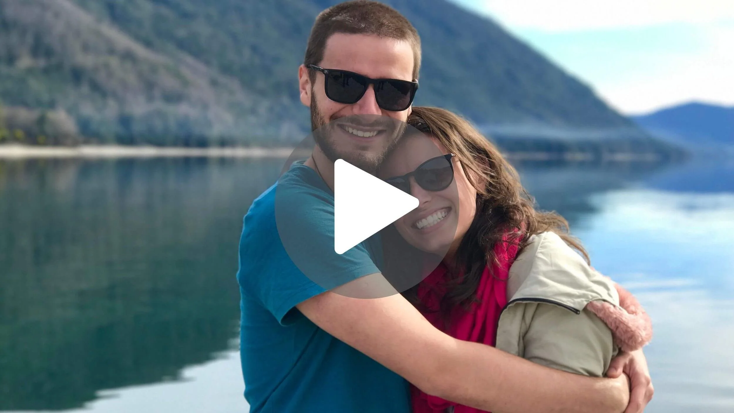 a married couple near a lake smiling