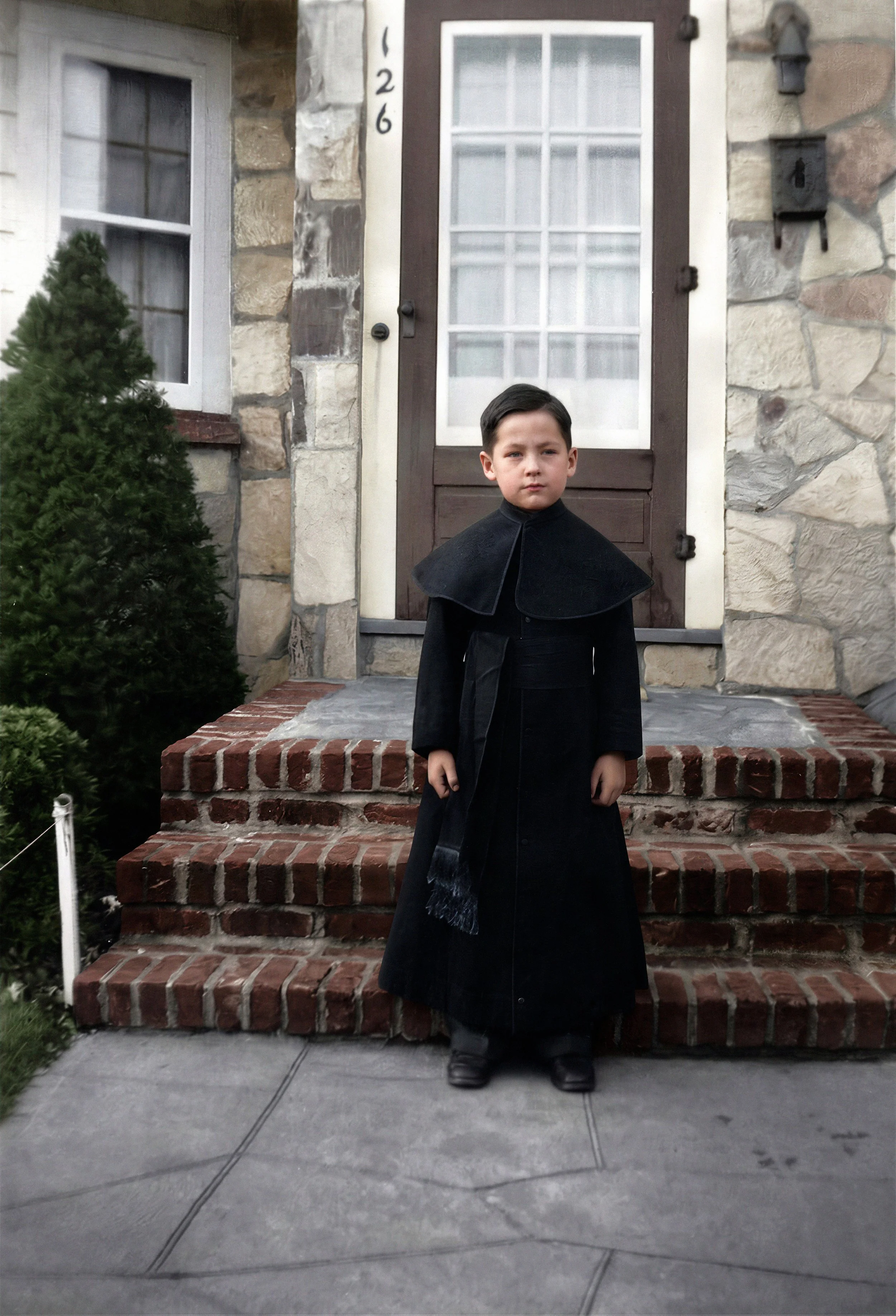 In what we believe was an appearance in a play or pageant at St. Michael School, Joe is dressed as a parish priest.
