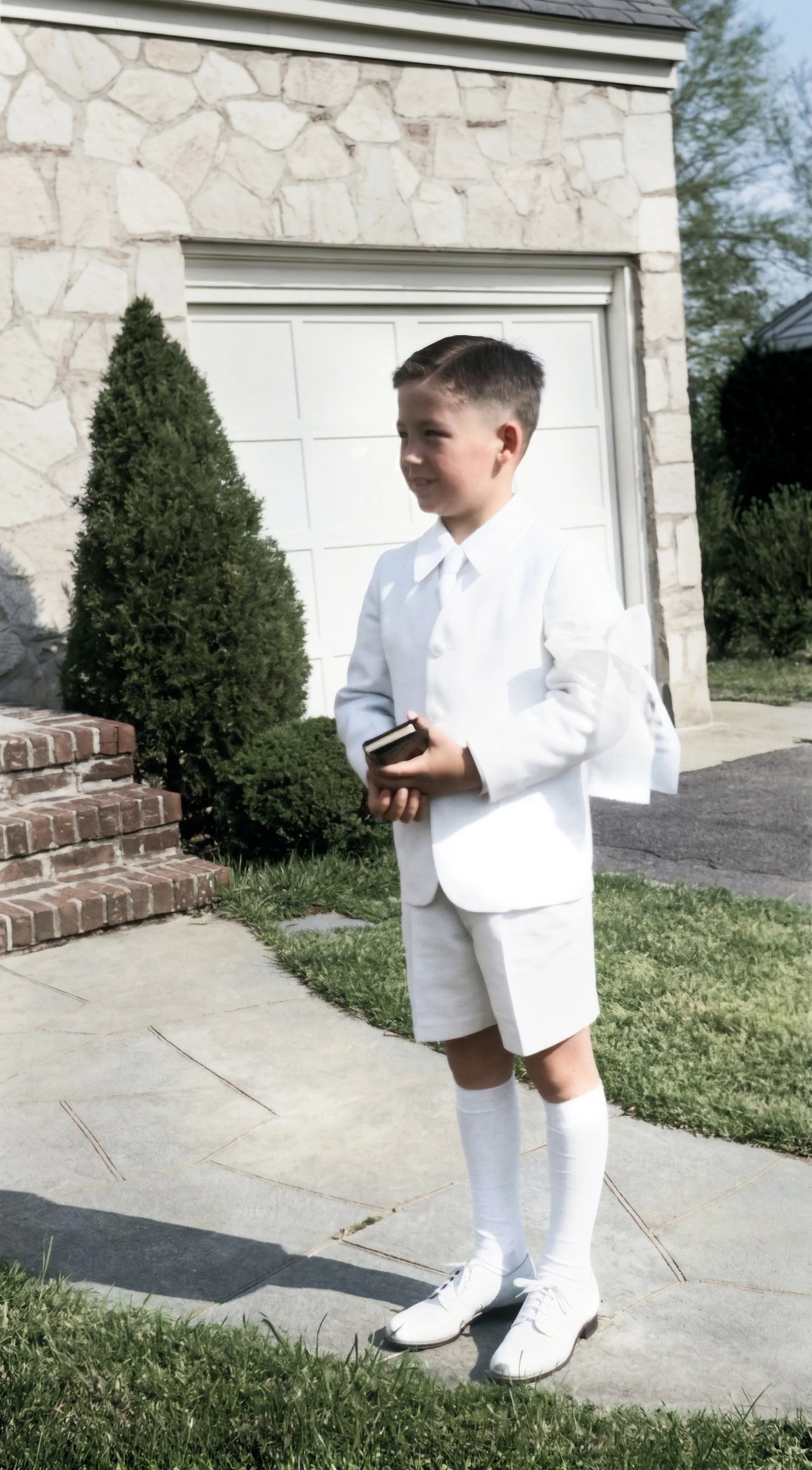 Sporting the traditional white shorts and sport coat and with bible in hand, Joe is ready for his First Holy Communion at St. Michael Church.