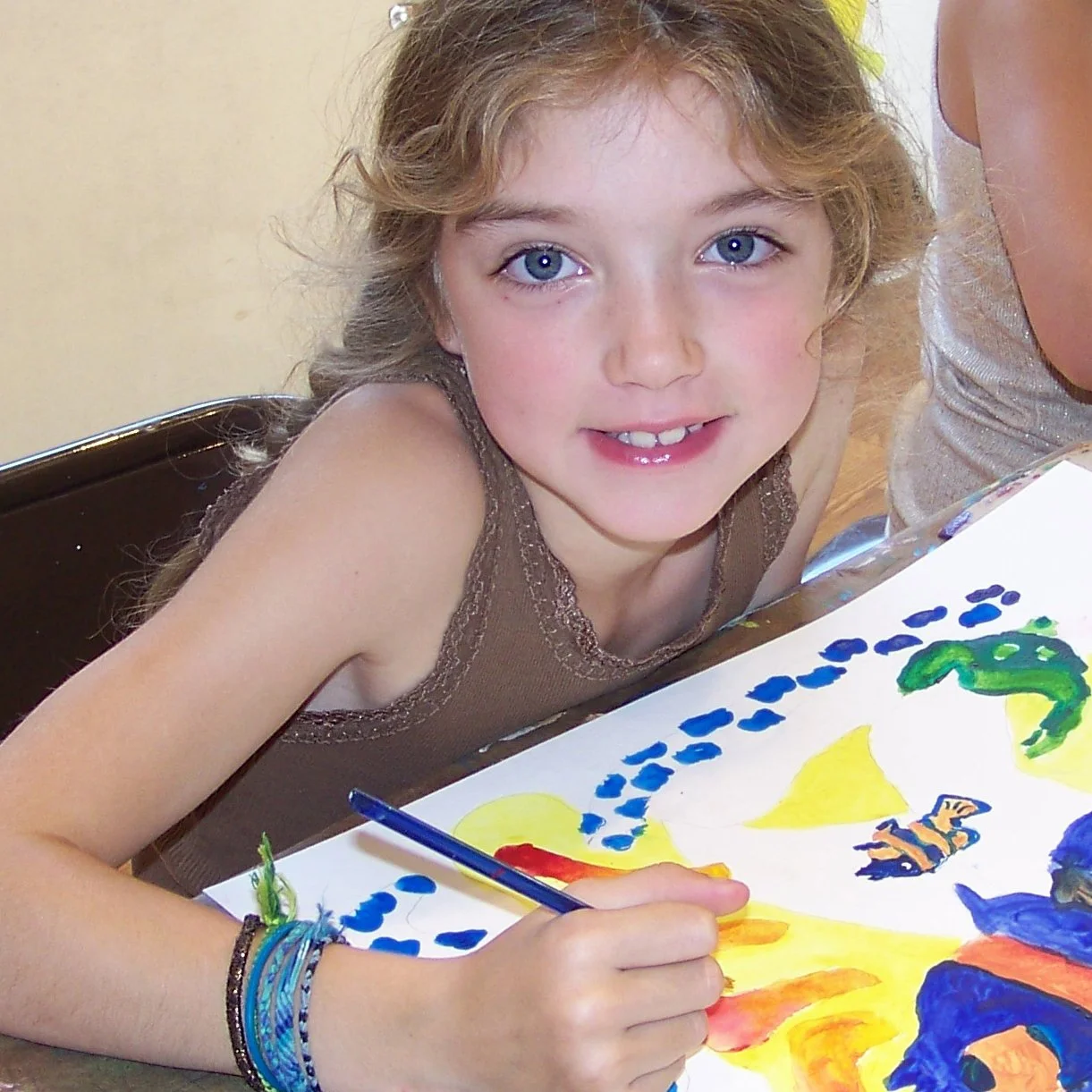 girl smiling while painting