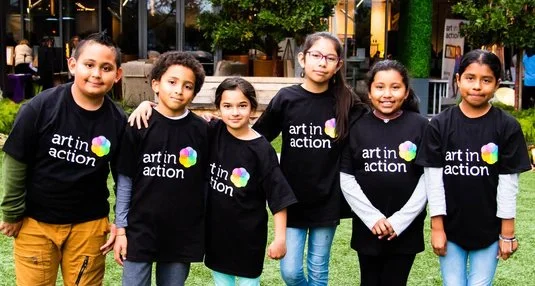 four students wearing Art in Action t-shirts