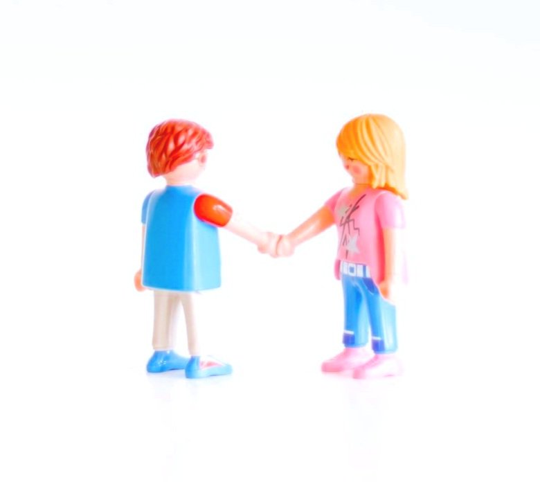 two bright colorful figures shaking hands