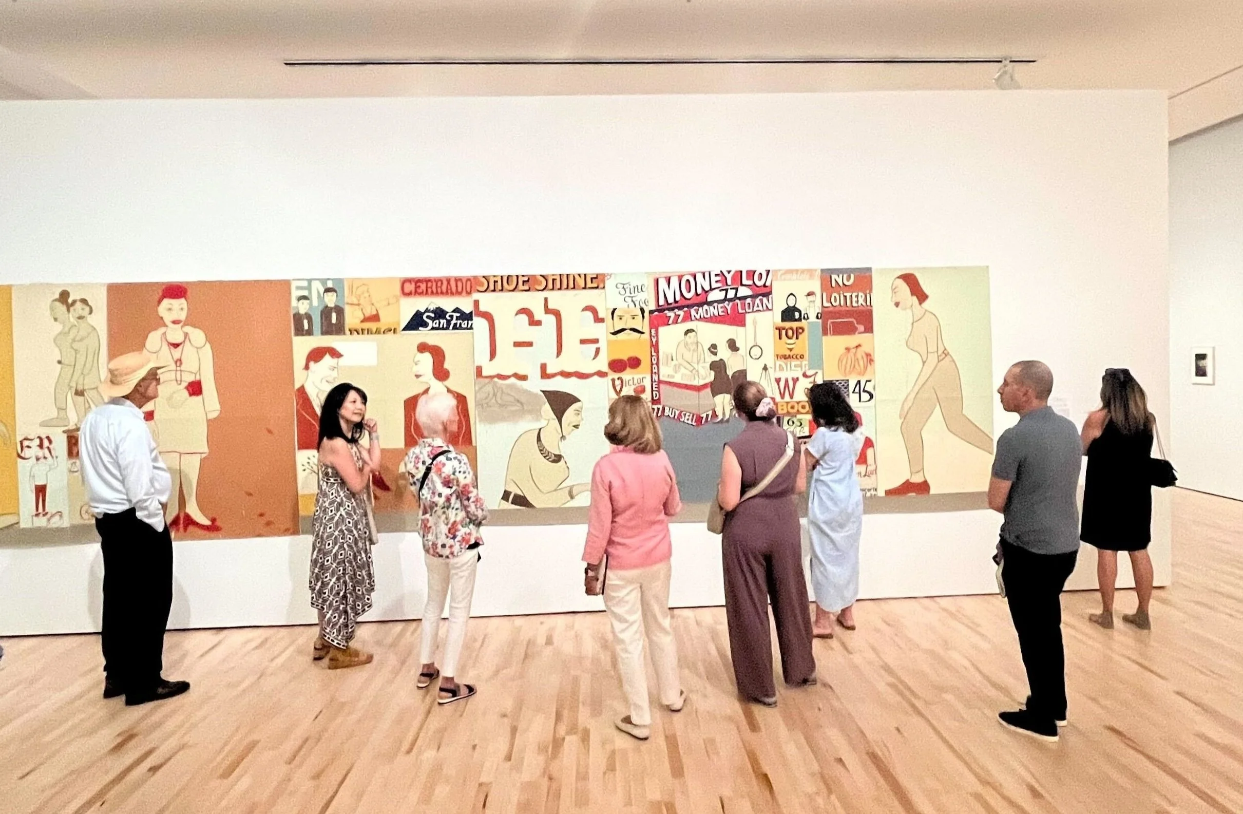 People viewing a large collage of artwork in an art gallery.