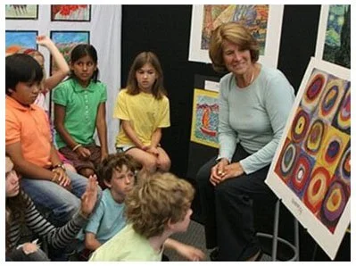Art in Action founder (Judy Sleeth, right) presenting artwork to students