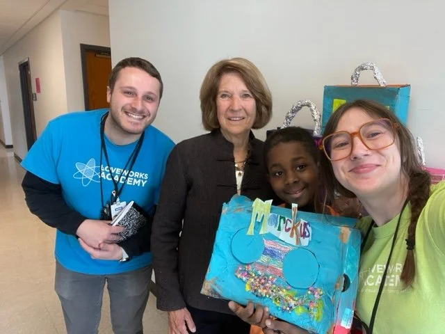 educator with children holding up their art