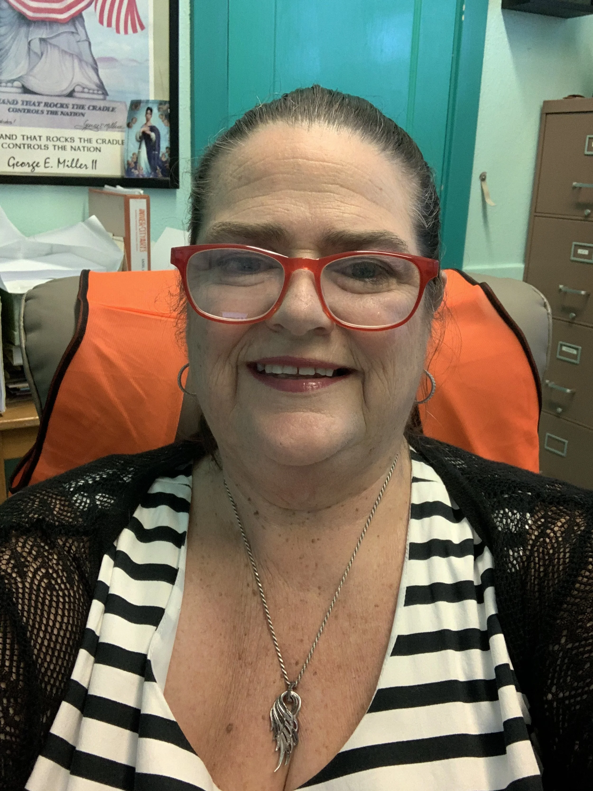 Debbie Evers Allen headshot with her smiling and wearing red eyeglass and striped shirt