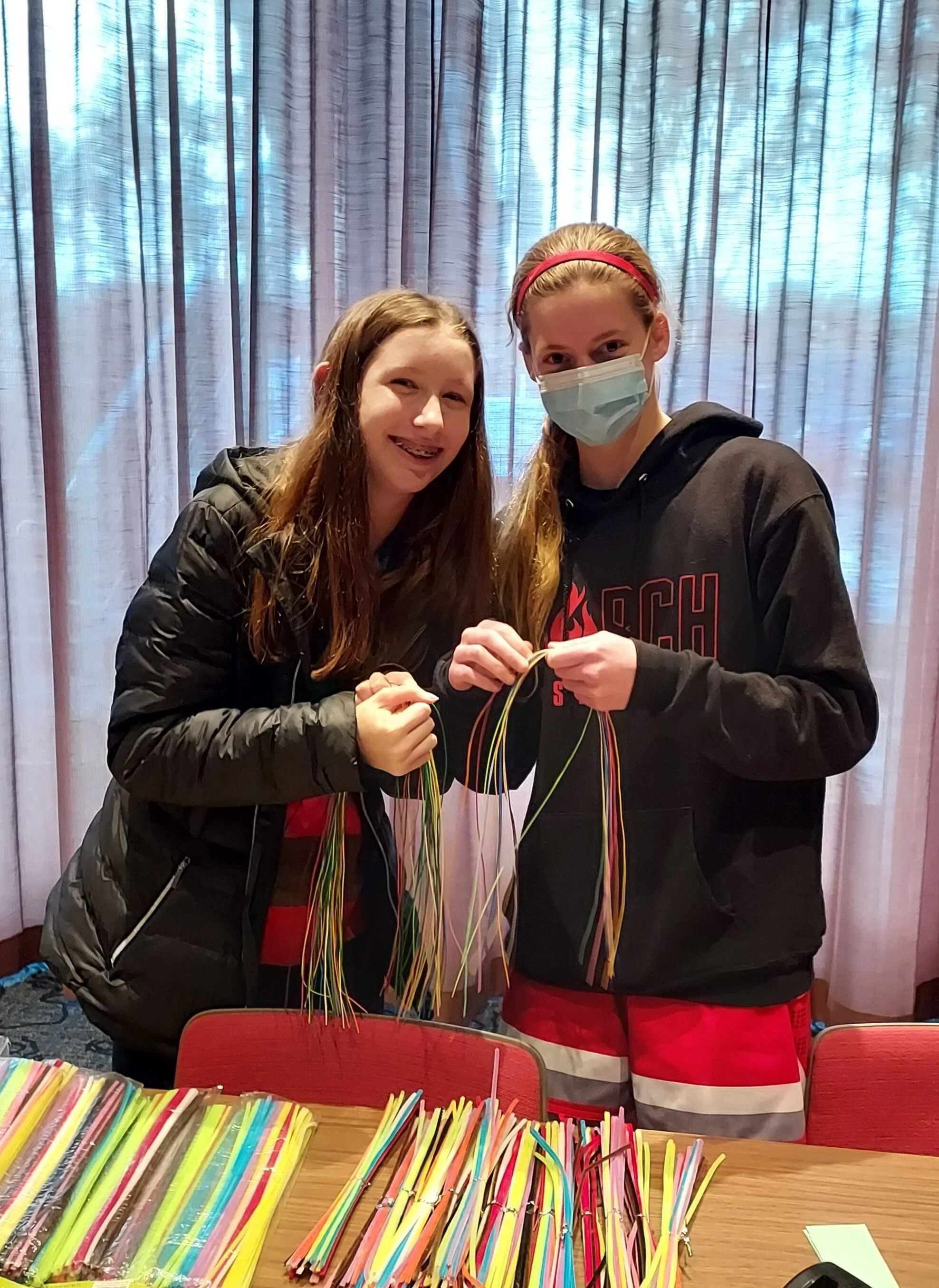 volunteers smiling while packing pipe-cleaners