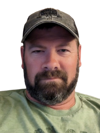 A man with light skin, short dark hair, and a beard, smiling in a professional portrait. He is wearing a navy blue suit jacket and a white dress shirt.