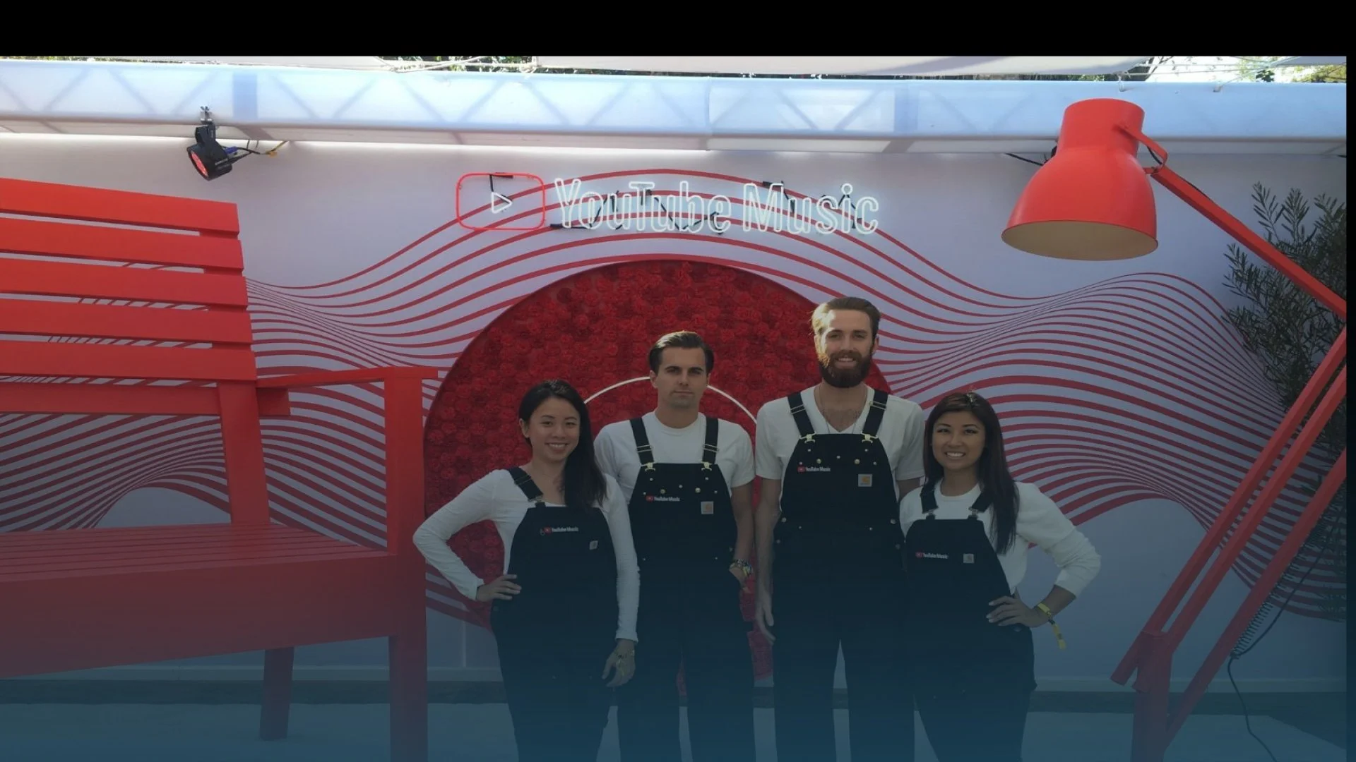 YouTube Music brand ambassadors and event staff wearing branded overalls posing in front of an experiential promotional booth display - Event Staffing Live