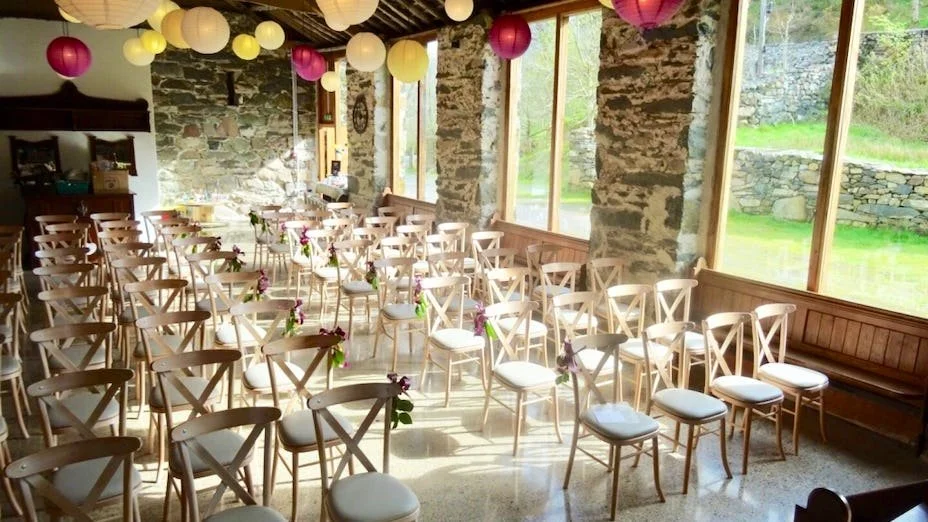Barn wedding venue North Wales, a shot of a ceremony set up inside the barn with natural light shining through the window