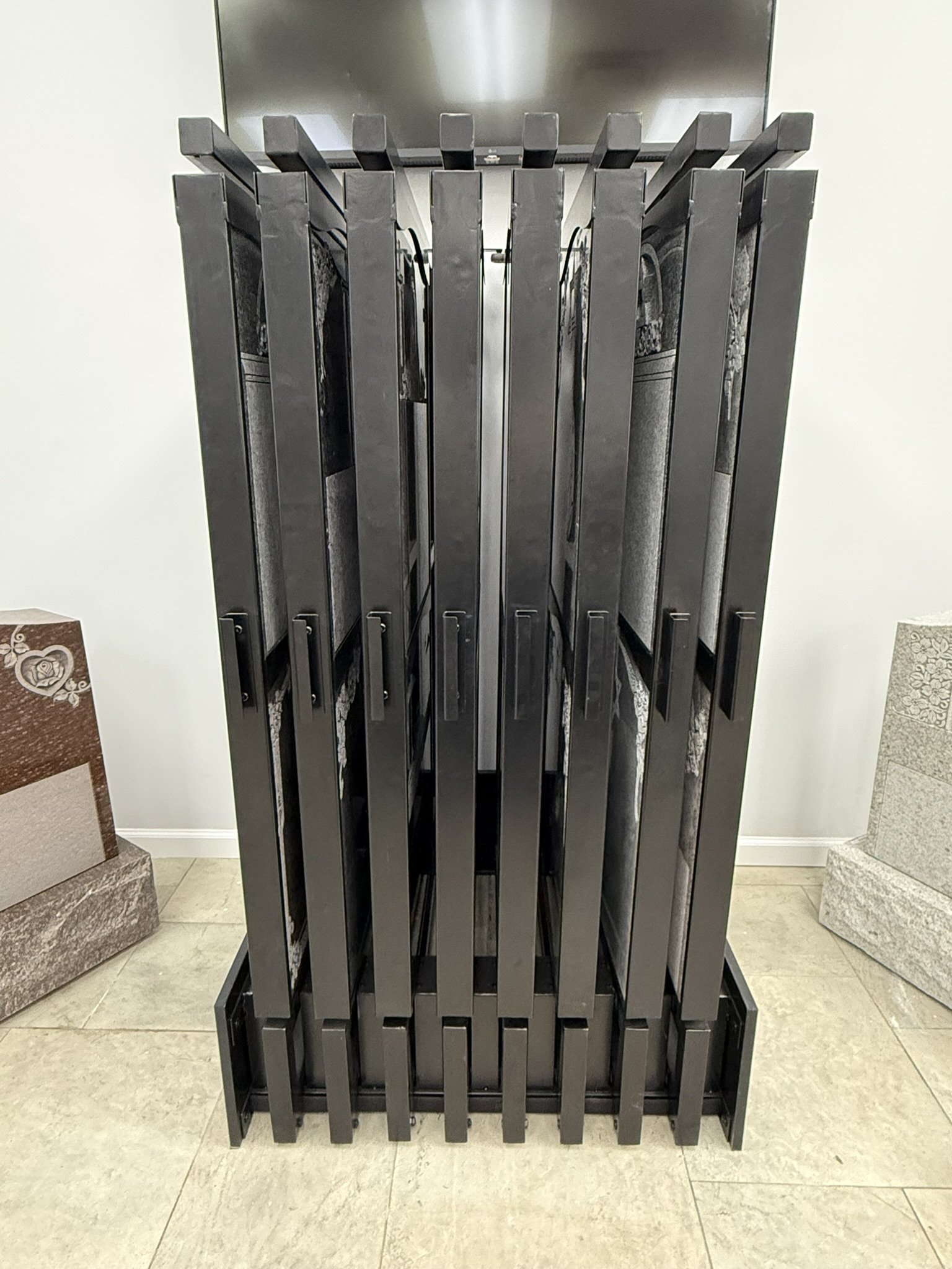 A display of various stone or tile samples arranged vertically on a stand in a showroom.