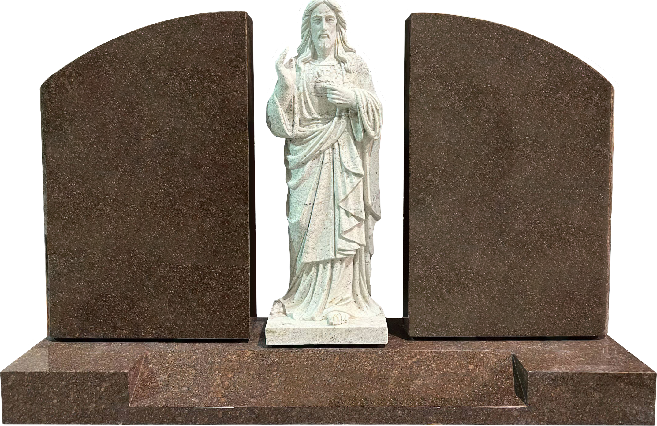 White marble statue of Jesus Christ with one hand raised and the other touching their chest, placed between two large dark brown stone structures.