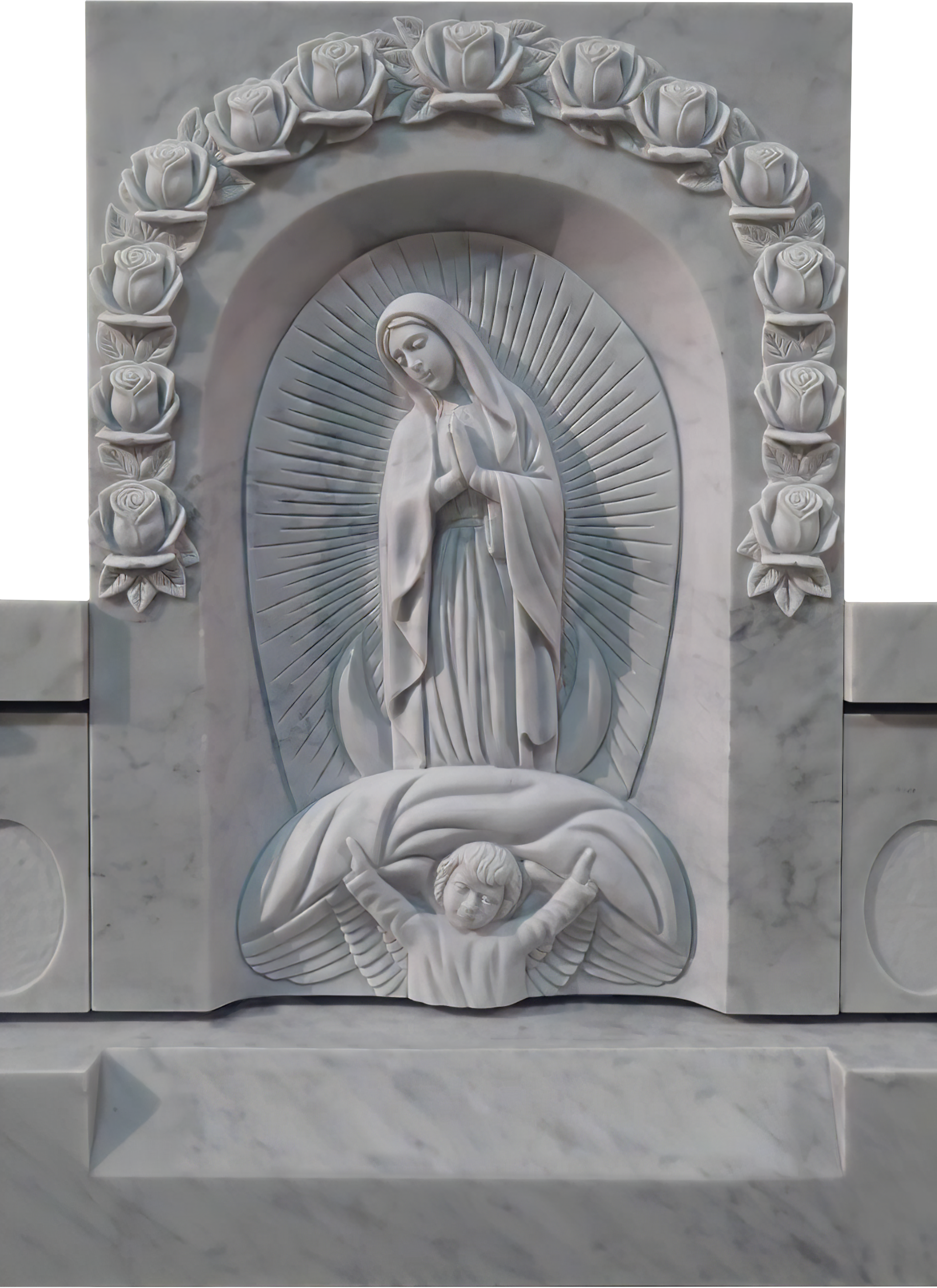 White marble religious relief sculpture depicting the Virgin Mary with hands in prayer, surrounded by a halo of rays, with an angel beneath her and a border of roses.