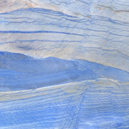 Close-up of a textured, layered stone surface with shades of blue and off-white.