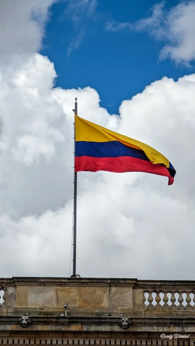 The Colombian flag flying over the central square of Bogota. Normally Bogota has some rainy weather, but this is a particularly sunny but cloudy day.