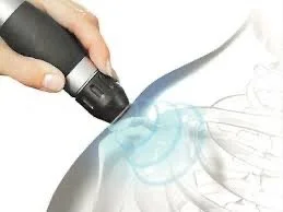 Close-up of a hand holding a shockwave handle applying focused sound waves to an injured shoulder.