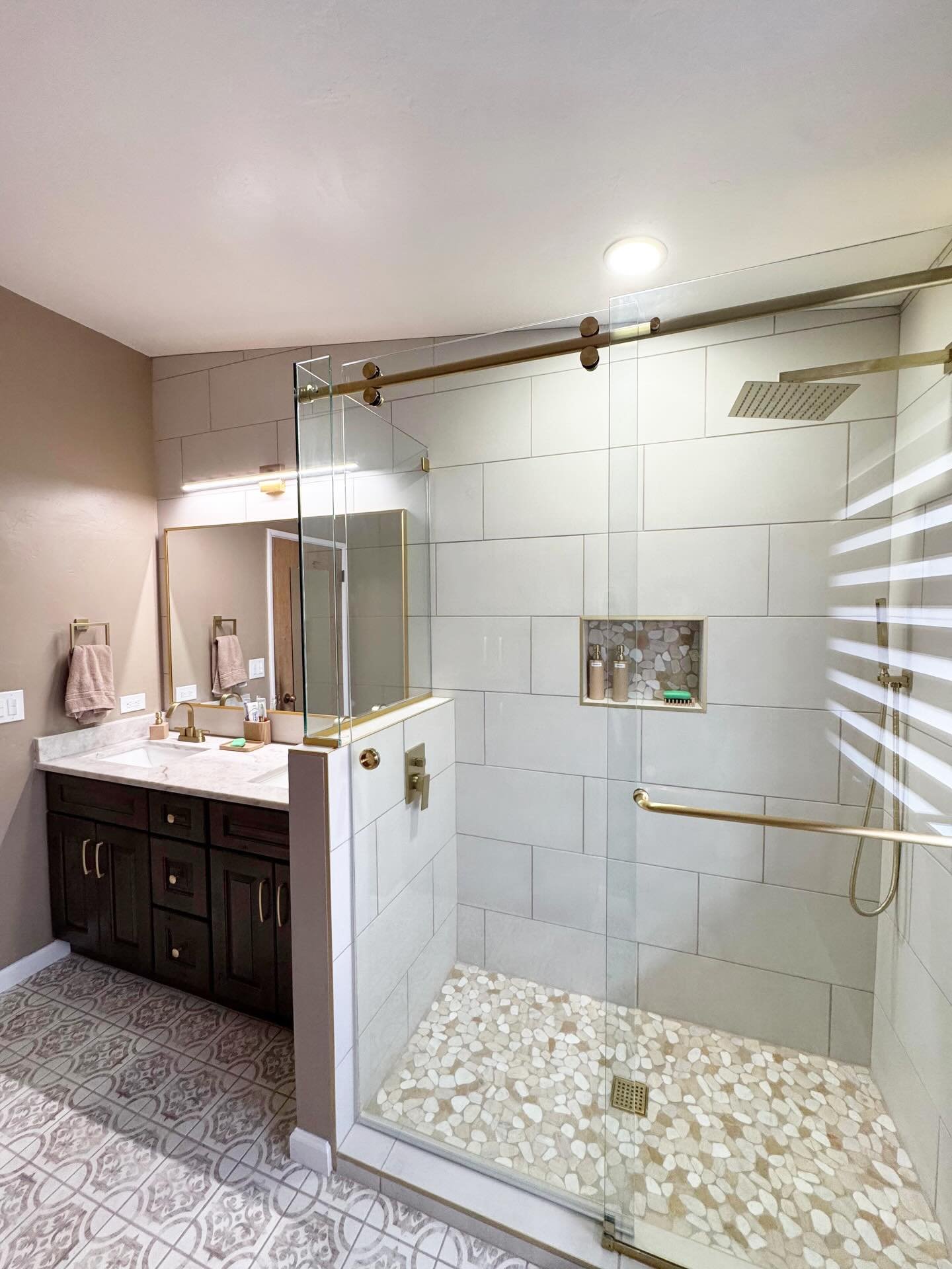 BEFORE AND AFTER❗️ Take a look at these 2 bathrooms we remodeled. What a total upgrade and transformation for these happy customers! We chose to go with warm and earthy tones to compliment the brushed gold fixtures. We love those rustic 8x8&rsquo;s d