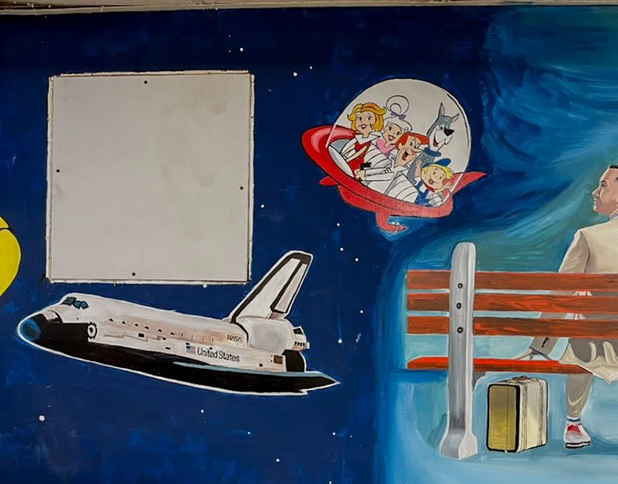 Space shuttle lower left side, Jetson's in upper center, Forest Gump sitting on bench on right side