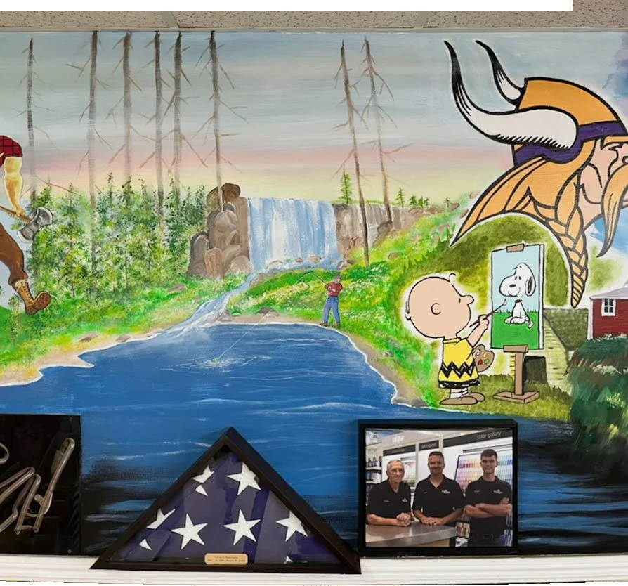 Waterfall in center surrounded by a forest, man fishing in lake below it, Charlie Brown painting Snoopy under Vikings football logo on right