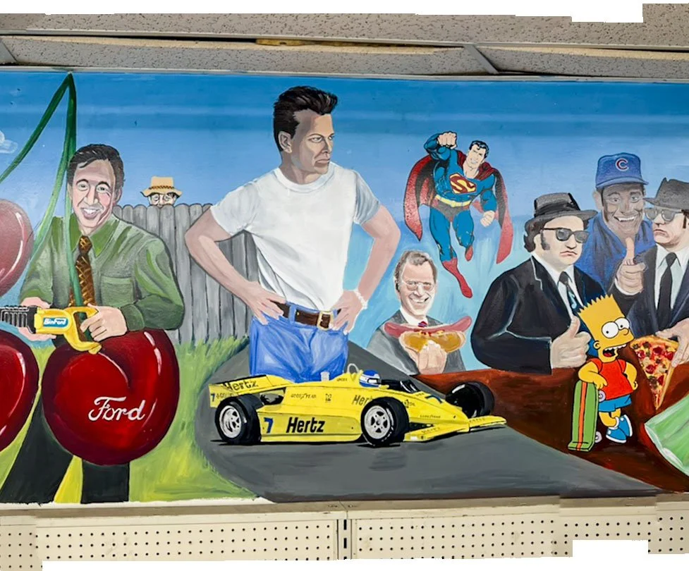 Cherry with Ford logo on left under Tim Allen holding reciprocating saw, neighbor peeking over fence in background, F1 car in front center, James Dean in background center, Superman flying to his right, David Letterman holding hot dog below Superman