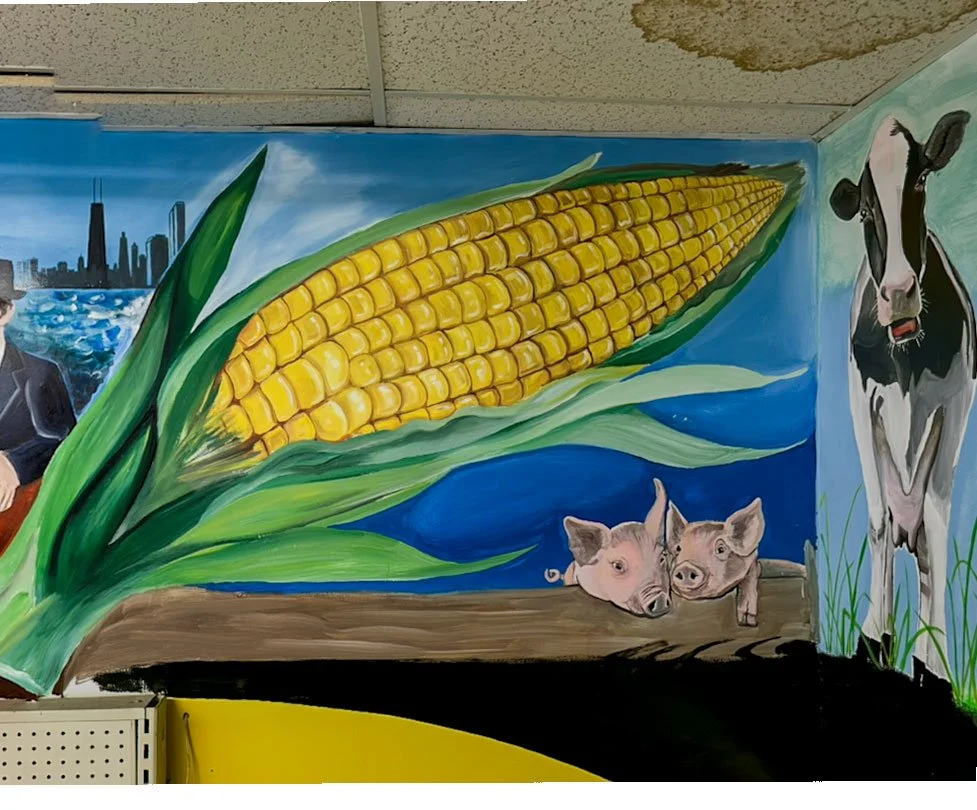 Chicago skyline in upper left corner, large cob of corn in center, two piglets underneath, cow on right side