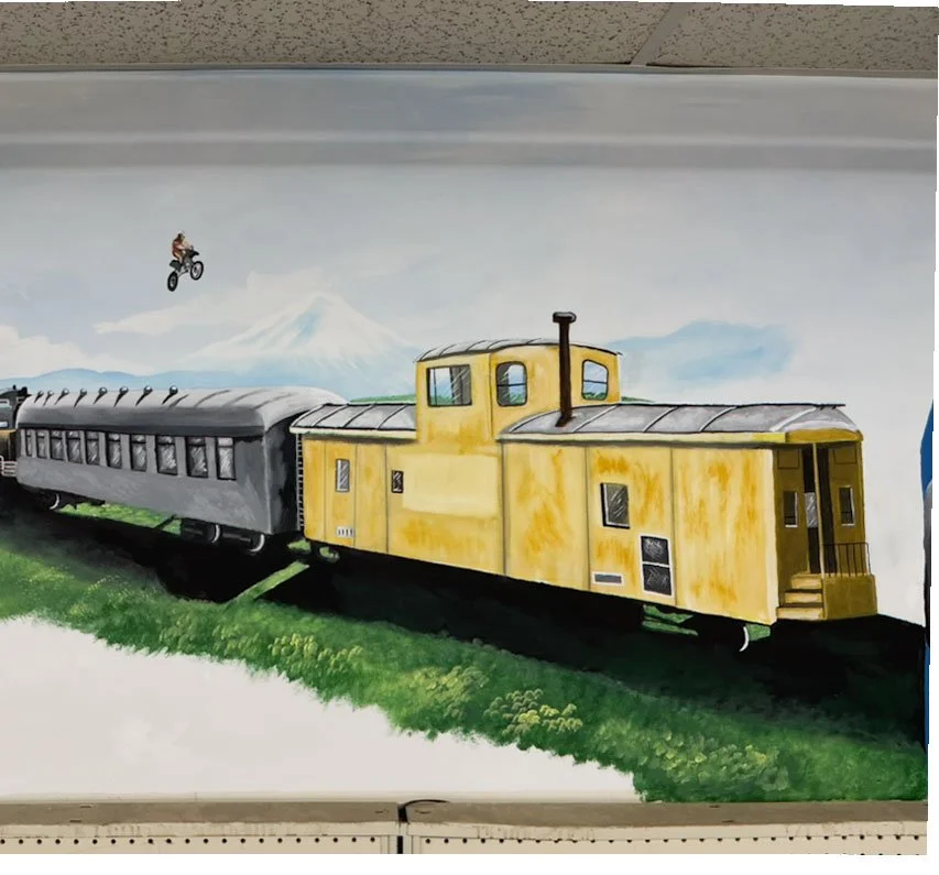 train in foreground with motorcycle jumping over it