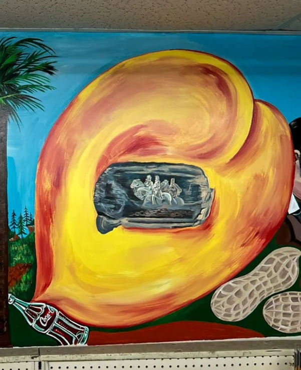 palm tree lines left side, large peach in the center with monument in middle, coca-cola bottle in bottom left corner, and peanuts in bottom right corner