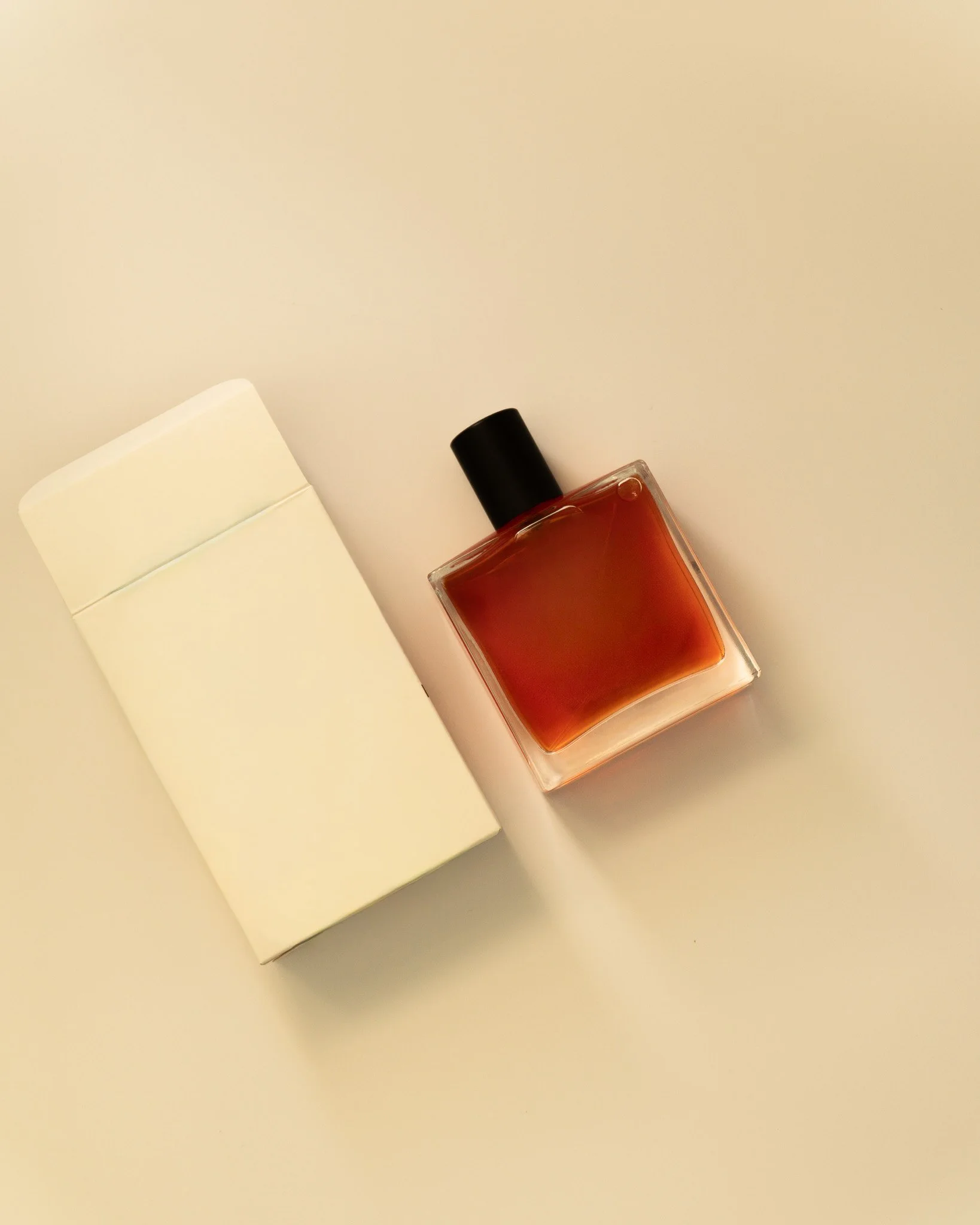 A perfume bottle next to its package