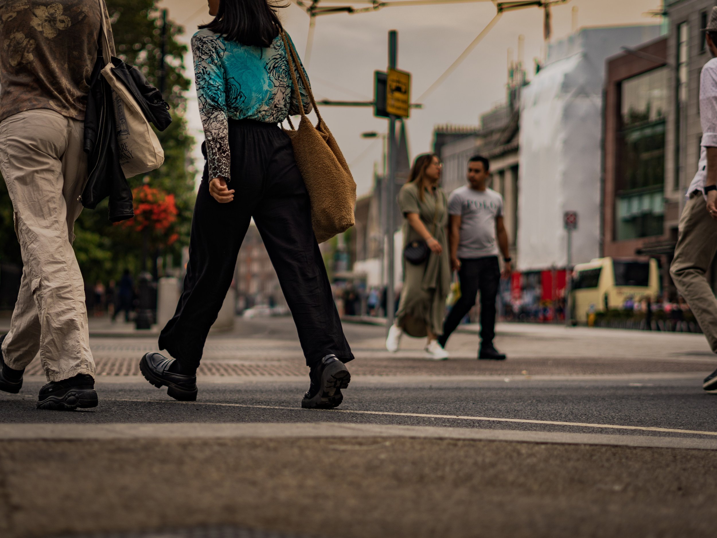 People crossing the street in an urban area during daytime.