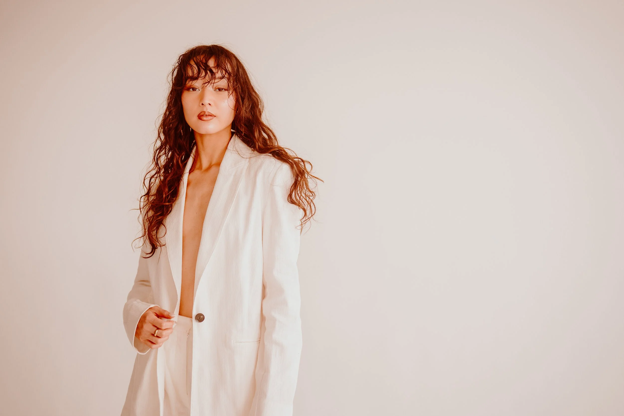 Melbourne model Soph Xu, wearing white suit, plenty of attitude, top open to reveal exposed torso, captured by photographer Campbell Mattinson.