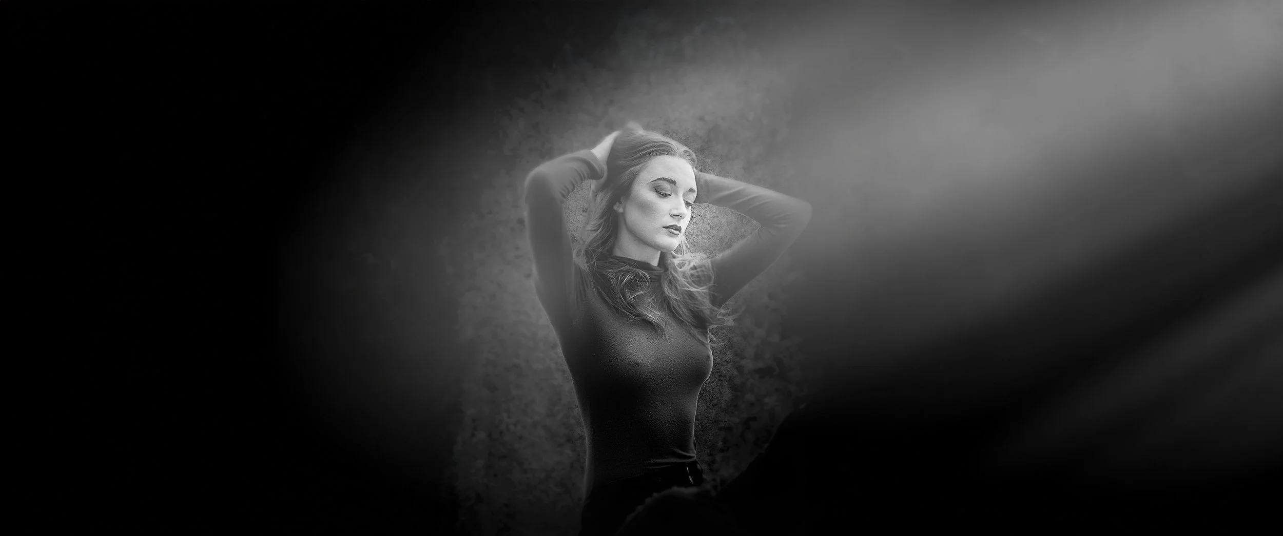 Australia actor Miranda Turbitt with her hands in her hair, sun coming in from the right, cinematic crop.