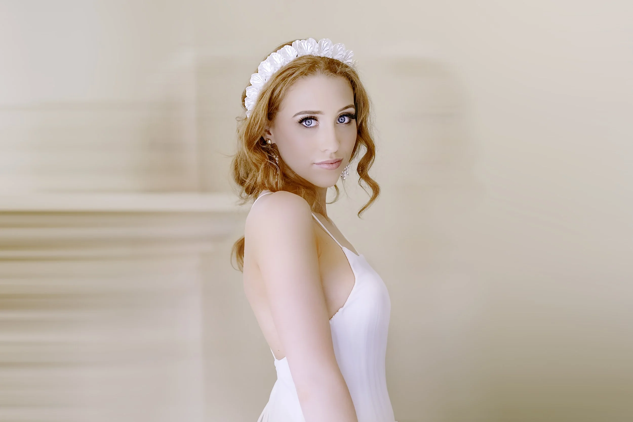 Model Laura Roberts, wearing a bohemian wedding dress, stares straight at the camera, red hair aflame.