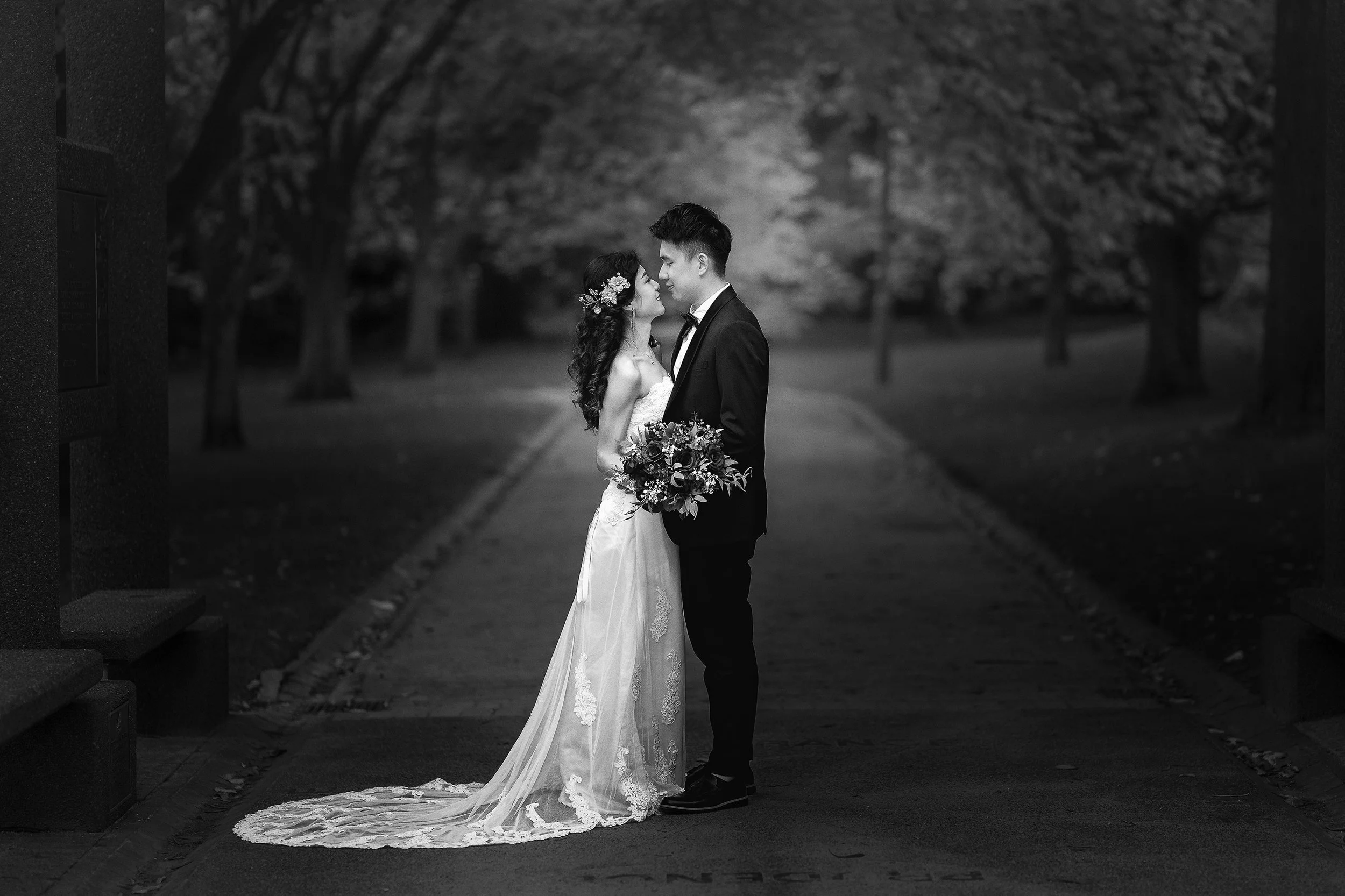 Husband and wife, wedding couple, stand in the Botanical Gardens in Melbourne in wedding clothes.