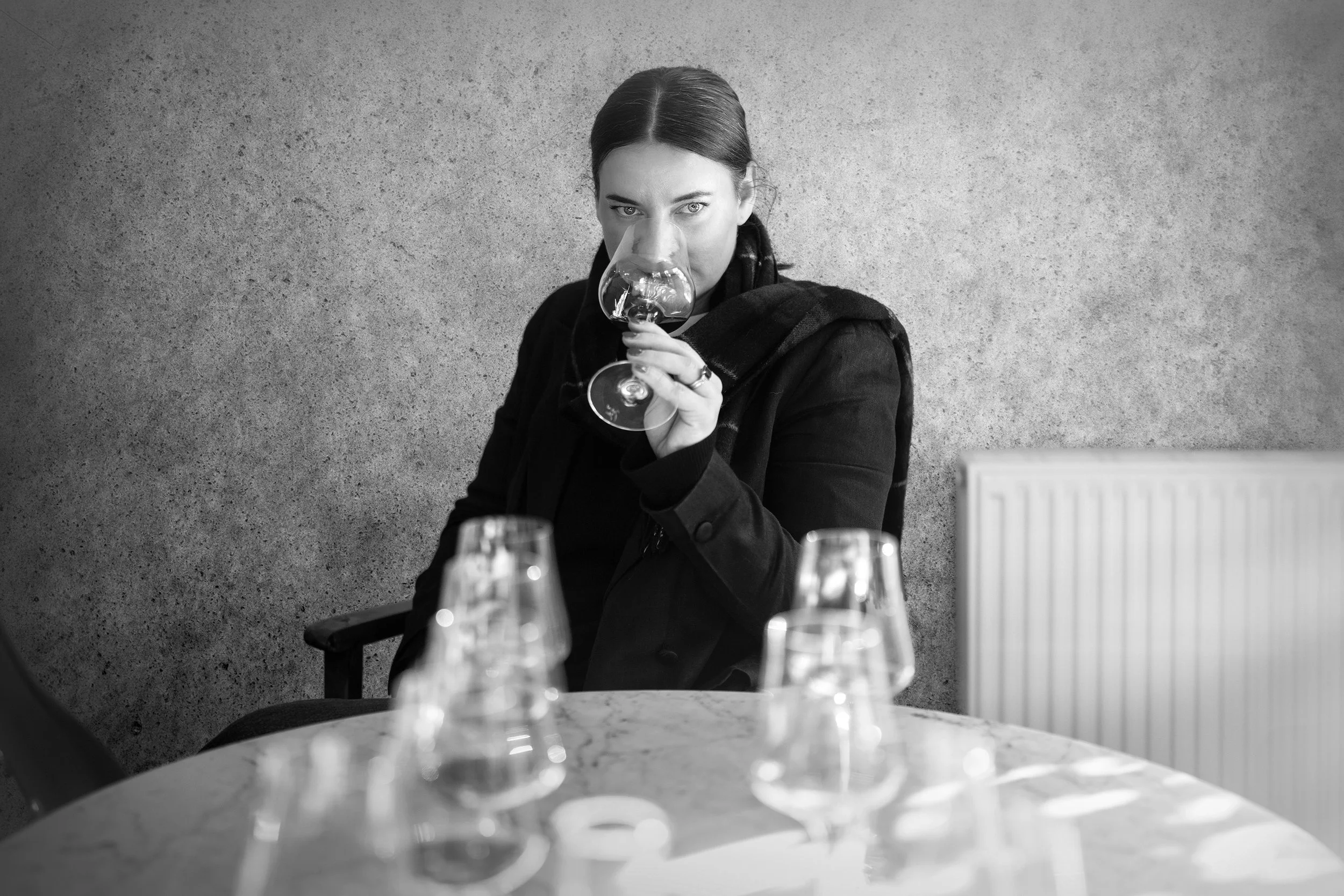 Giant Steps winemaker Mel Chester sitting at a table full of wine glasses, looking straight at the camera.