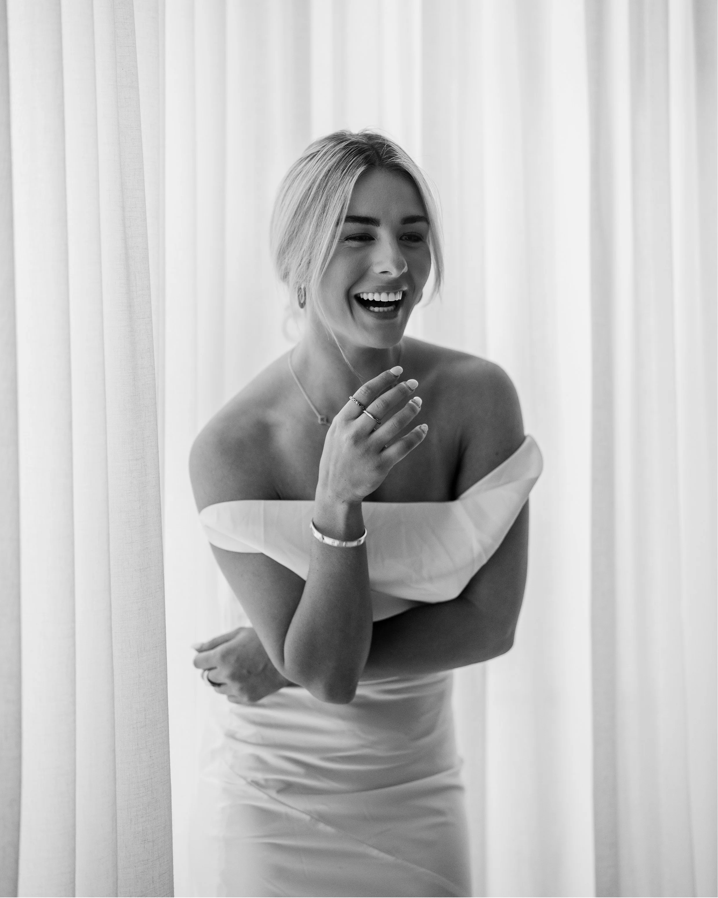 Model Shanelle Hodgkinson, wearing a white wedding dress, laughing.