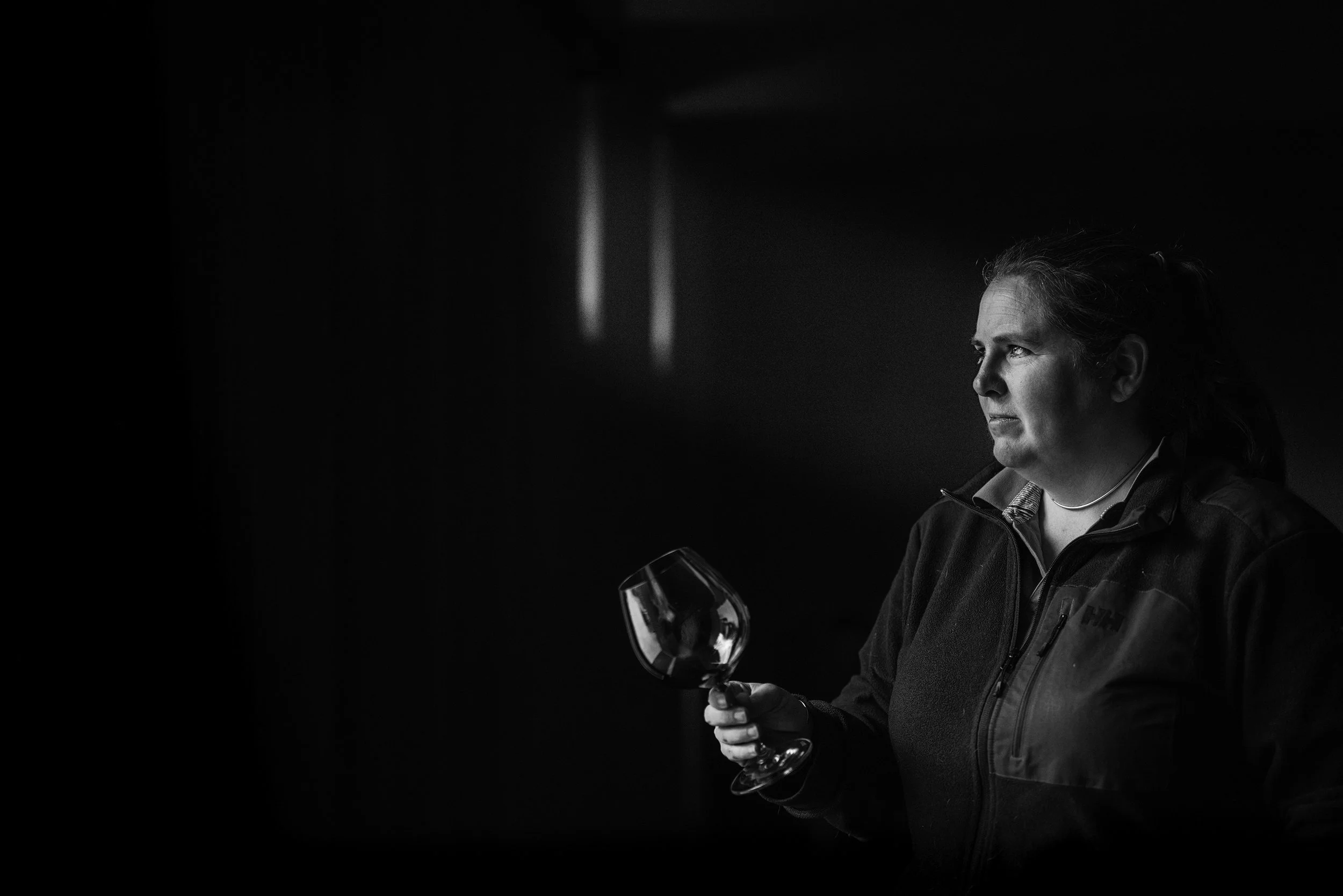 Black and white portrait of Tarrawarra winemaker Sarah Fagan, standing by a door at TarraWarra Estate.