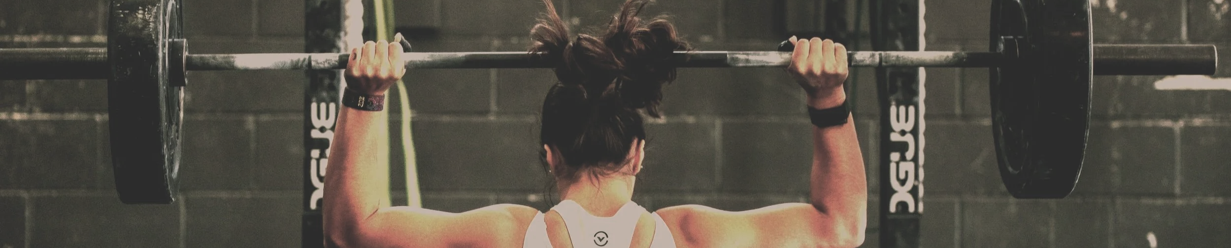 Woman lifting weights — building leadership strength  and discipline through executive coaching