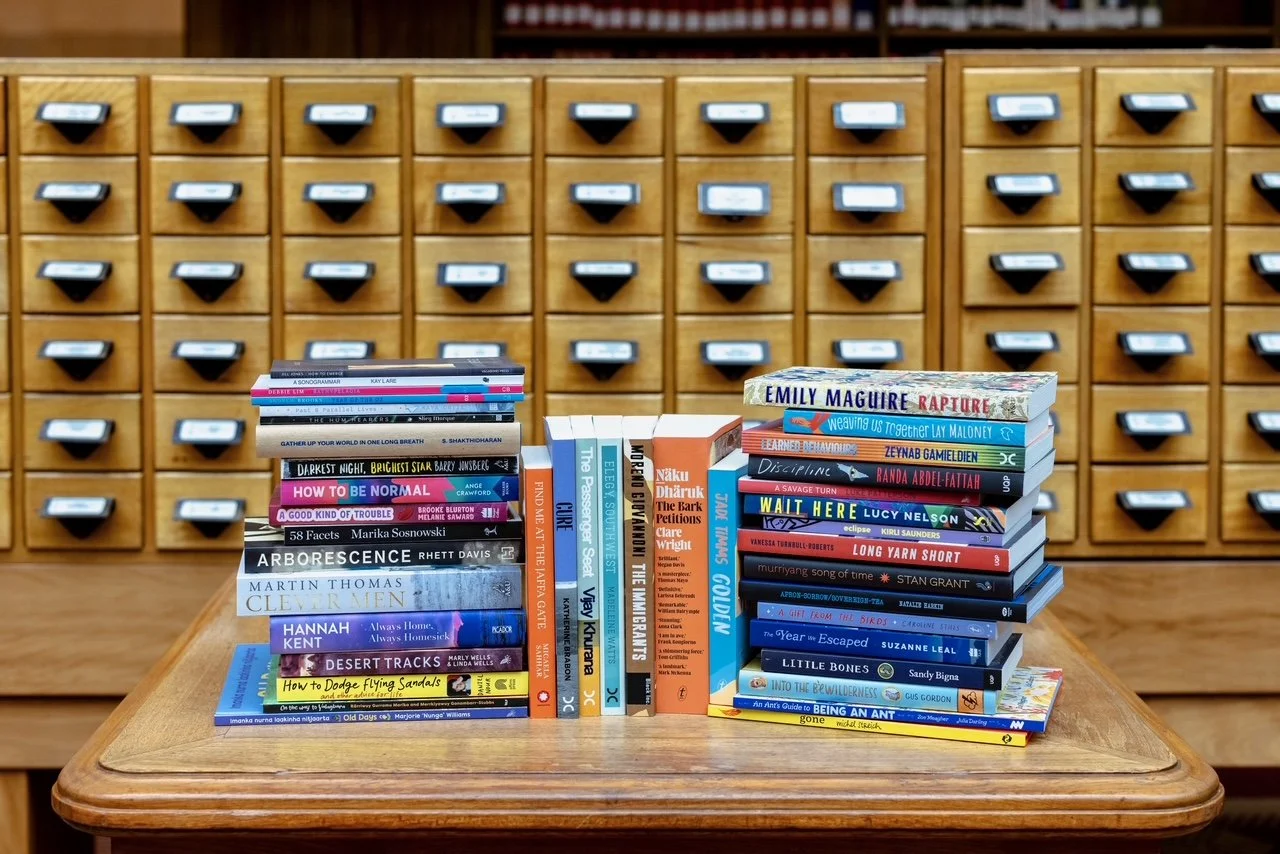 Stack of books on wooden table.