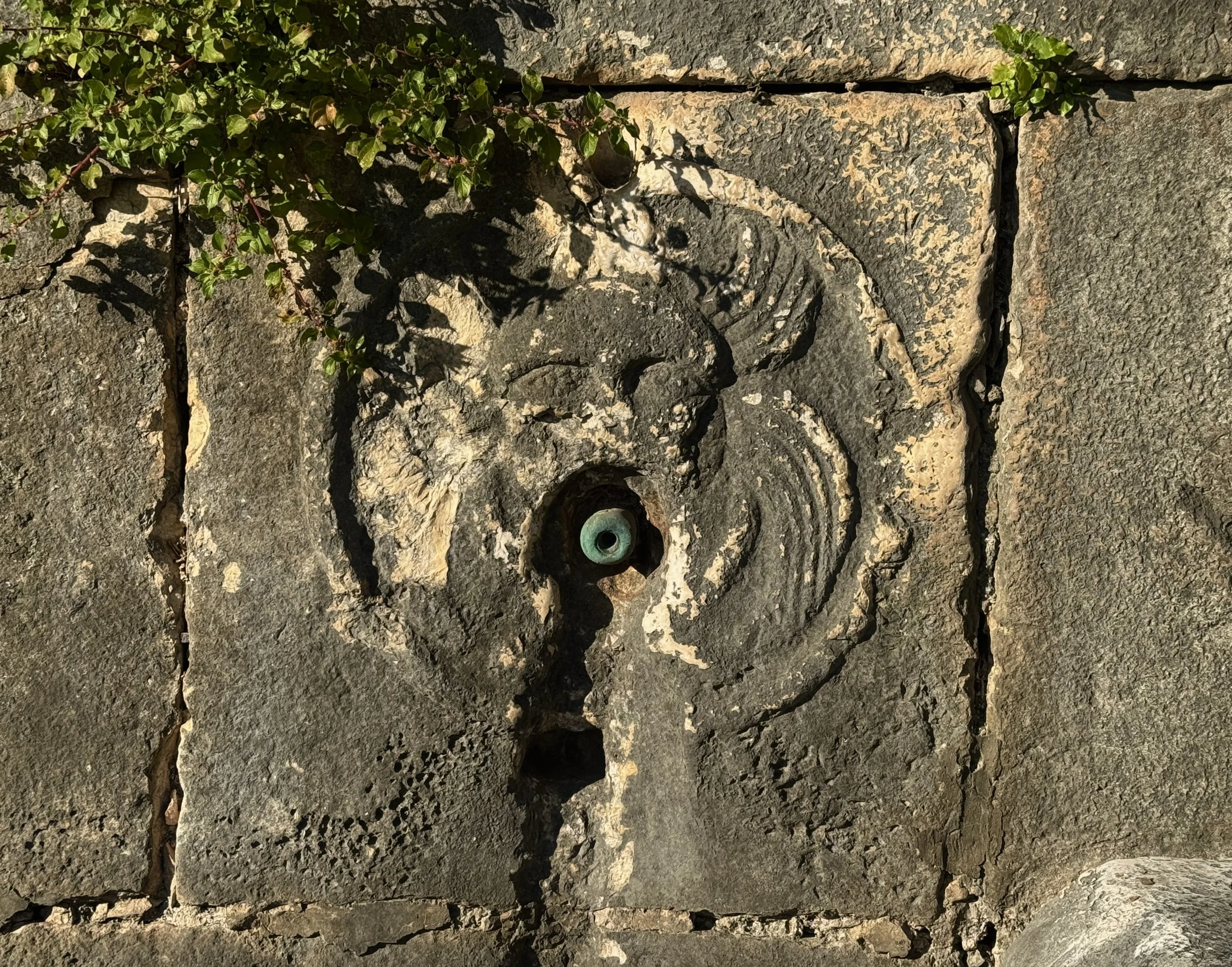 One of two spouts still visible.  Theater like masks of sun and moon.