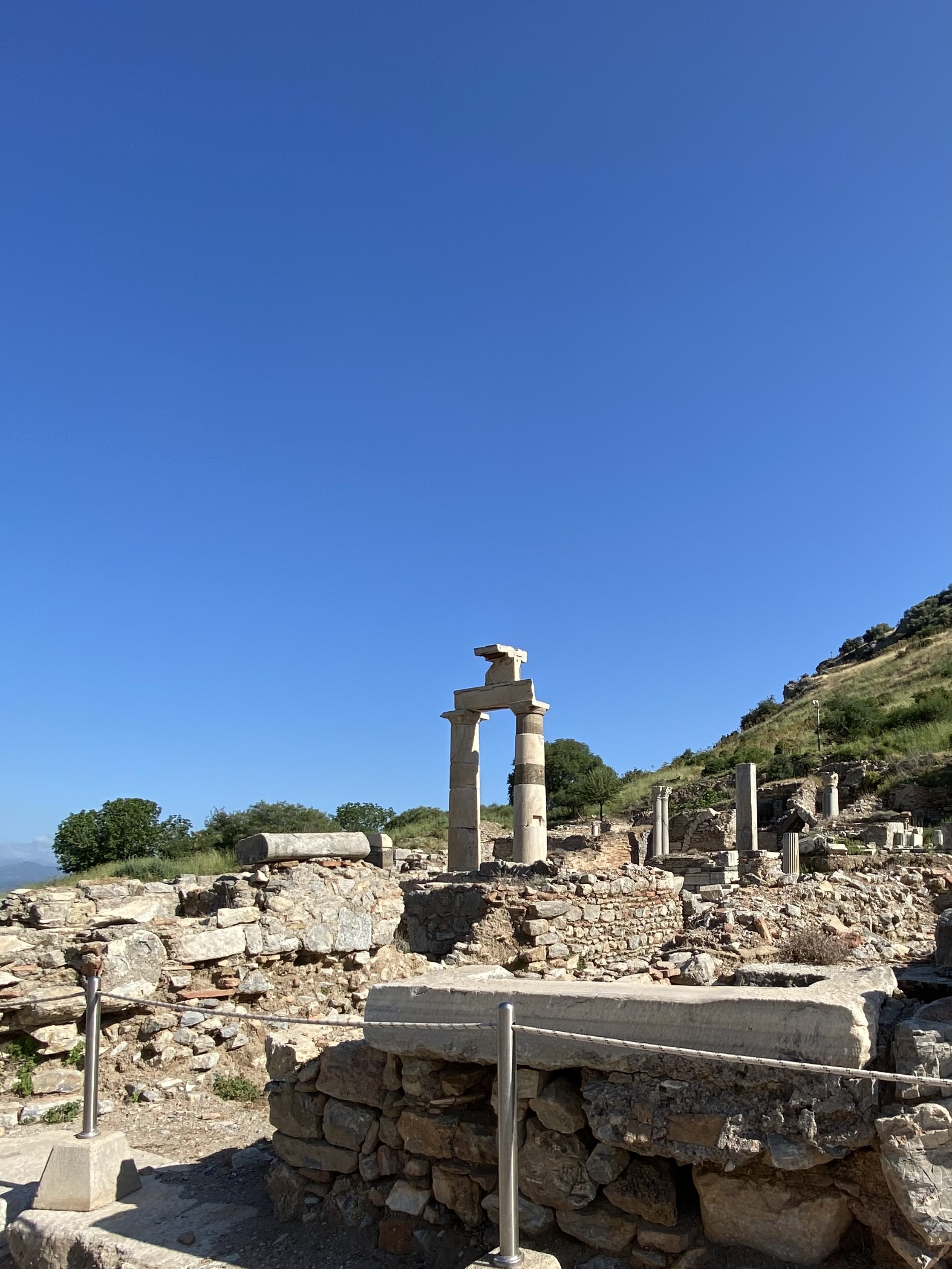 "Temenos of Dea Roma and Divus Julius Caesar" - Agora Temple. All that remains is an elevated platform between the Odion and the Prytaneion (town hall - the upright columns in this photo). 