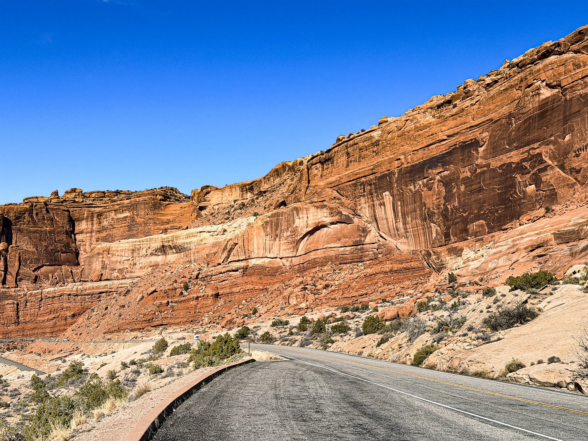 Fresh fault line cutting through layered red sandstone cliffs inside Arches National Park near the visitor center, illustrating recent movement along the Moab Fault system.